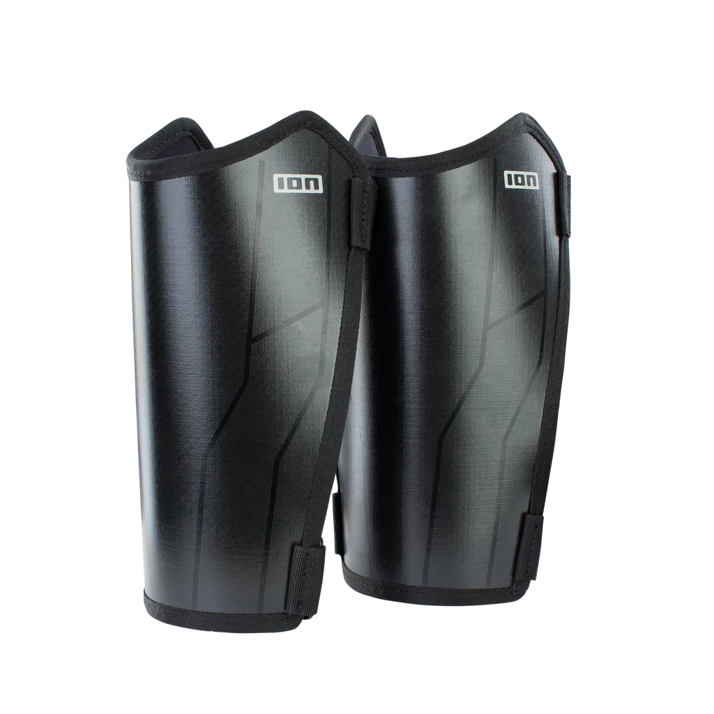 A pair of black shin guards with a subtle textured finish and the brand logo 'ION' printed in white on the upper front, set against a plain white background.